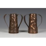 Two similar Arts and Crafts Newlyn twin-handled copper vases of conical form, each body worked