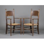 A pair of early 20th century Arts and Crafts ash panel back armchairs, after a design by William