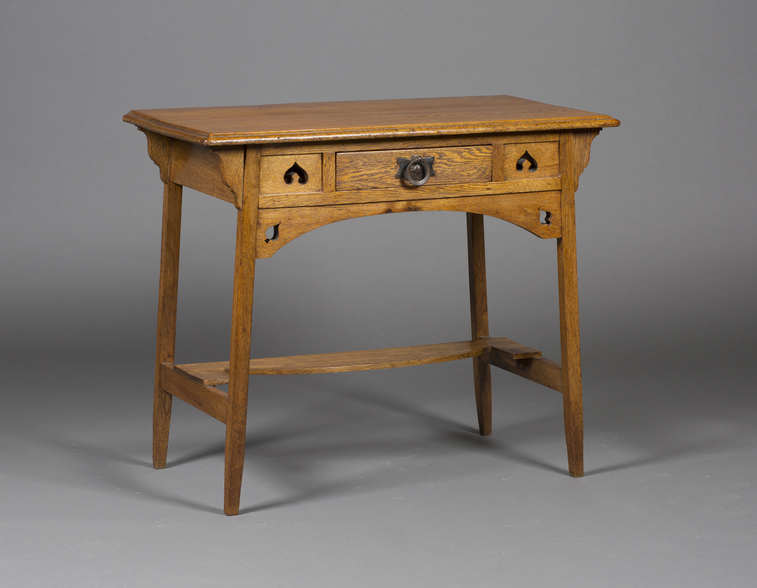 An early 20th century Arts and Crafts oak side table, in the manner of Liberty & Co, the frieze