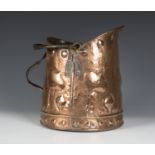 An Arts and Crafts polished copper coal bucket with applied wrought iron handles, the hammered