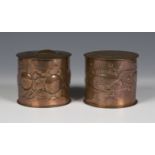 Two Arts and Crafts Newlyn copper jars and covers of cylindrical form, one decorated with overall