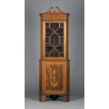 An Edwardian mahogany and foliate inlaid corner cabinet, the swan neck pediment above an astragal