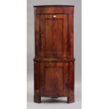 An early 19th century Continental figured mahogany bowfront two-tier corner cabinet, the moulded