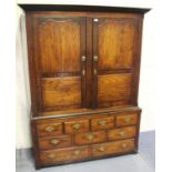 An 18th century provincial elm livery cupboard, the moulded pediment above a pair of panelled doors,