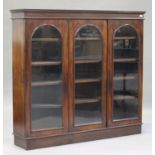 A Victorian mahogany bookcase, the moulded pediment above three arch glazed doors, on a plinth base,