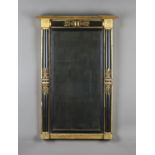 A Regency ebonized and giltwood pier mirror, the frame with ebonized pilasters and applied