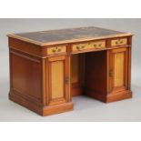 A Victorian satin walnut twin pedestal desk, the moulded top inset with brown tooled leather above