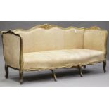 A late 19th century French giltwood framed settee with carved decoration, upholstered in golden