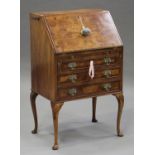 An early 20th century Queen Anne style burr walnut bureau with crossbanded borders, the fall front