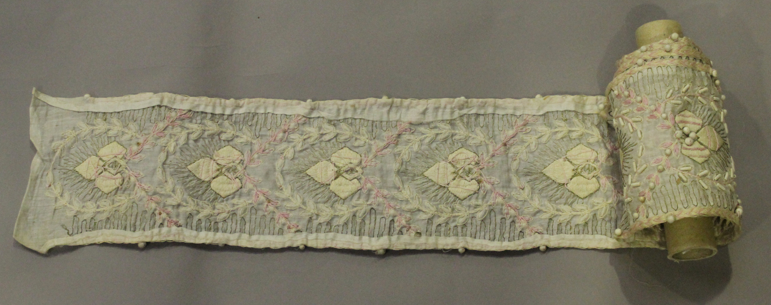 An early 20th century embroidered silk long band runner, worked in pink and cream silk with