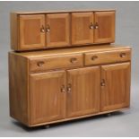 A mid-20th century Ercol elm sideboard, the cupboard back above drawers and further cupboards,