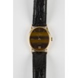 A Baume & Mercier Baumatic 18ct gold oval cased gentleman's wristwatch, the signed tiger's eye