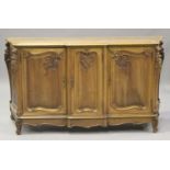 An early 20th century French walnut sideboard with carved scroll decoration, the moulded top above