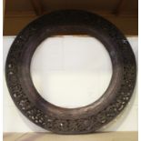 A 19th century Indian carved hardwood circular frame, pierced and carved with a band of