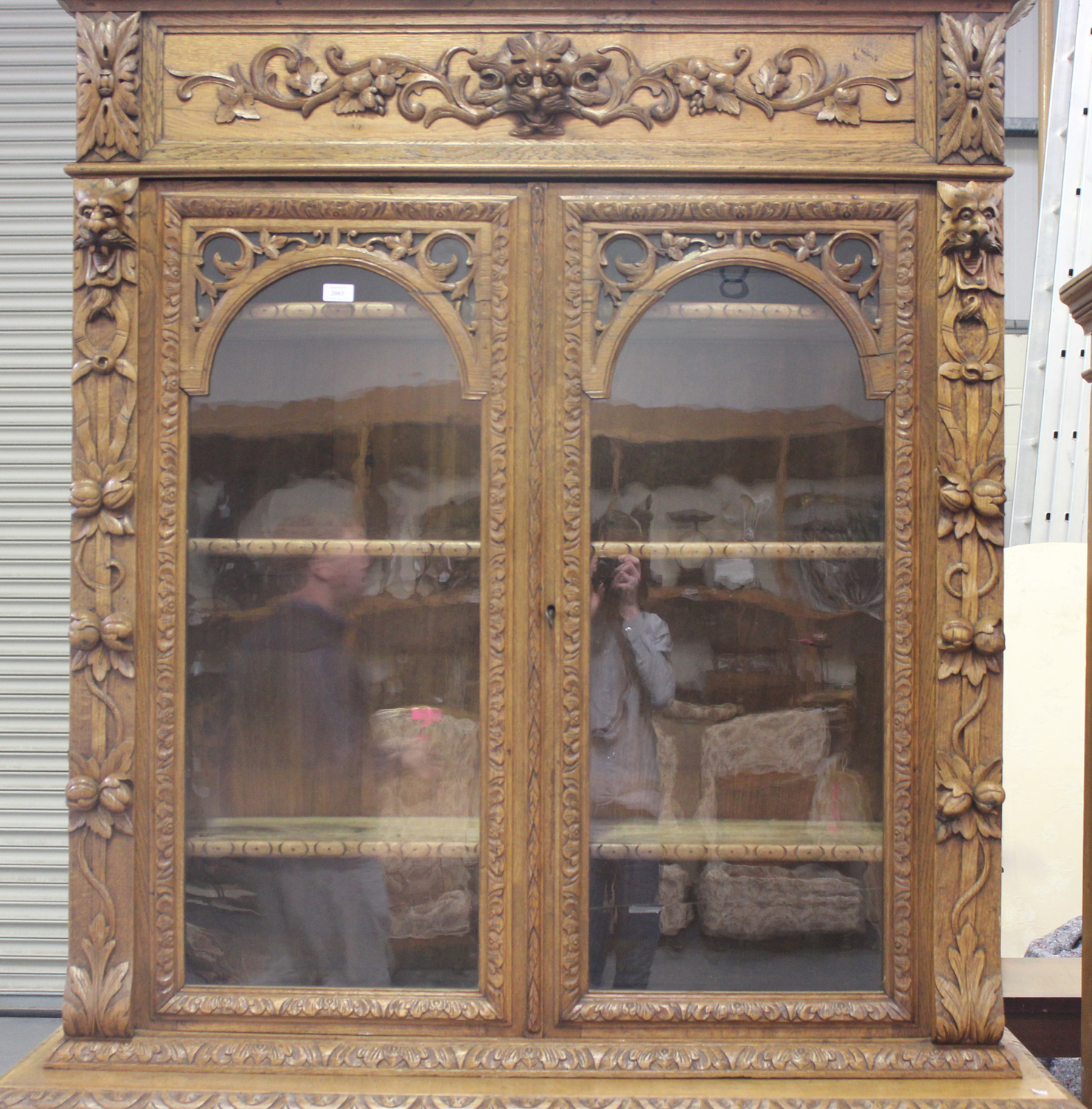 A mid-Victorian oak bookcase cabinet, profusely carved with floral scrolls and masks, the moulded - Image 3 of 4