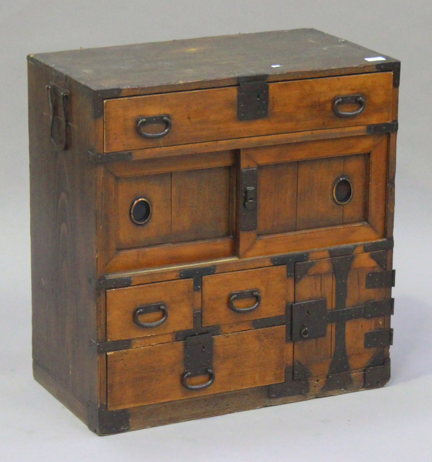 An early 20th century Japanese softwood side cabinet with wrought metal mounts, fitted with an