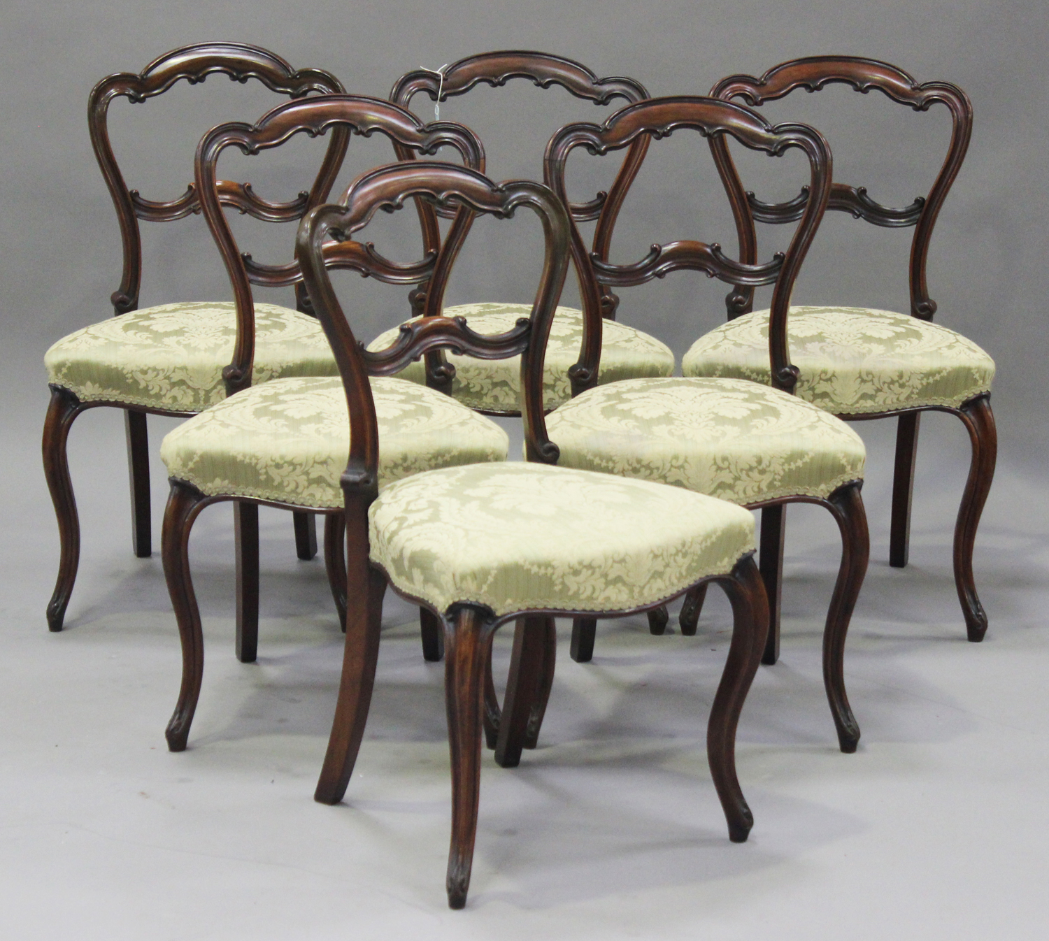 A set of six mid-Victorian rosewood spoon back dining chairs with carved decoration, the upholstered