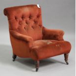 A late Victorian Howard style scroll and buttoned back armchair, raised on ring turned walnut legs