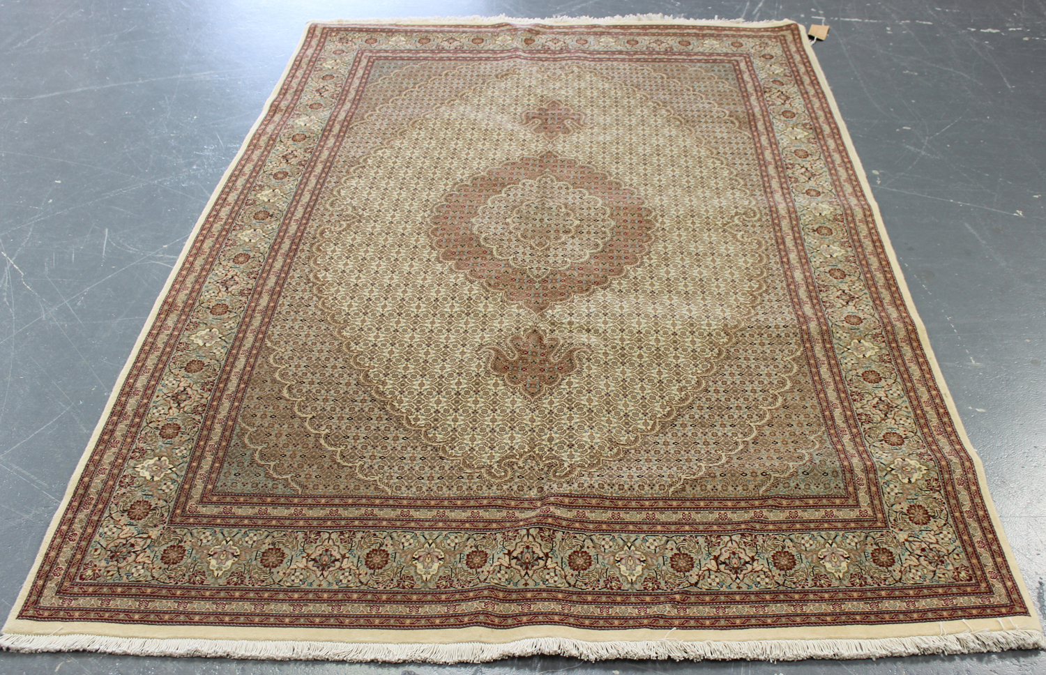 A Tabriz rug, Central Persia, modern, the ivory field with a lobed elliptical medallion, supported