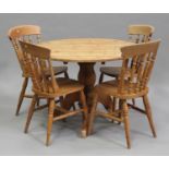 A modern pine circular kitchen table, height 75cm, diameter 107cm, together with a set of four