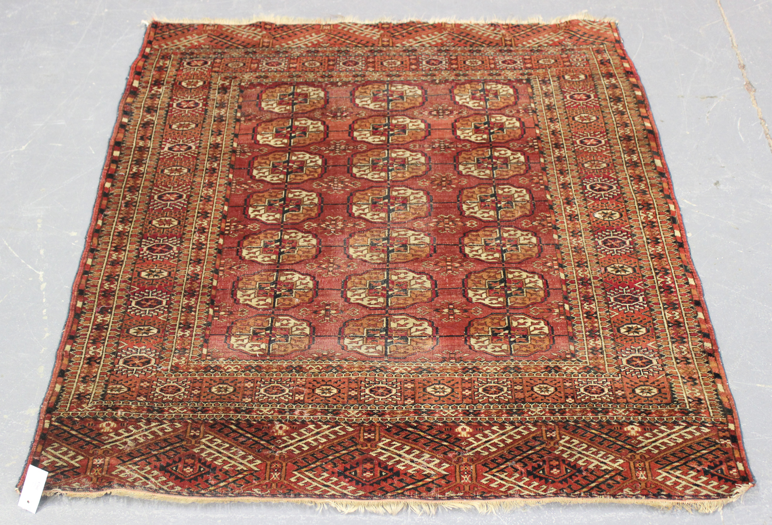 A Tekke rug, West Turkestan, early 20th century, the pale claret field with three columns of seven