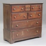 An 18th century provincial oak chest, fitted with an arrangement of eight drawers, on bracket