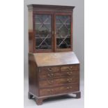 A George IIII mahogany bureau bookcase, the dentil moulded pediment above a blind fretwork frieze