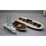 A mid-20th century wooden model boat hull with partial steam engine motor, length 101cm, together