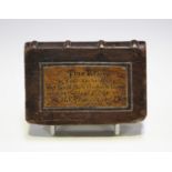 A 19th century carved wooden model of a book, one side inscribed in ink with 'This Relic of John