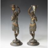 A pair of late 19th century Egyptianesque cast spelter figural candlesticks, heightened in gilt