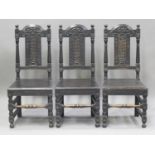 A set of six early 20th century Jacobean Revival stained oak dining chairs with carved decoration,