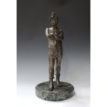 A 20th century patinated cast bronze figure of a Roman gladiator, standing with his arms crossed,