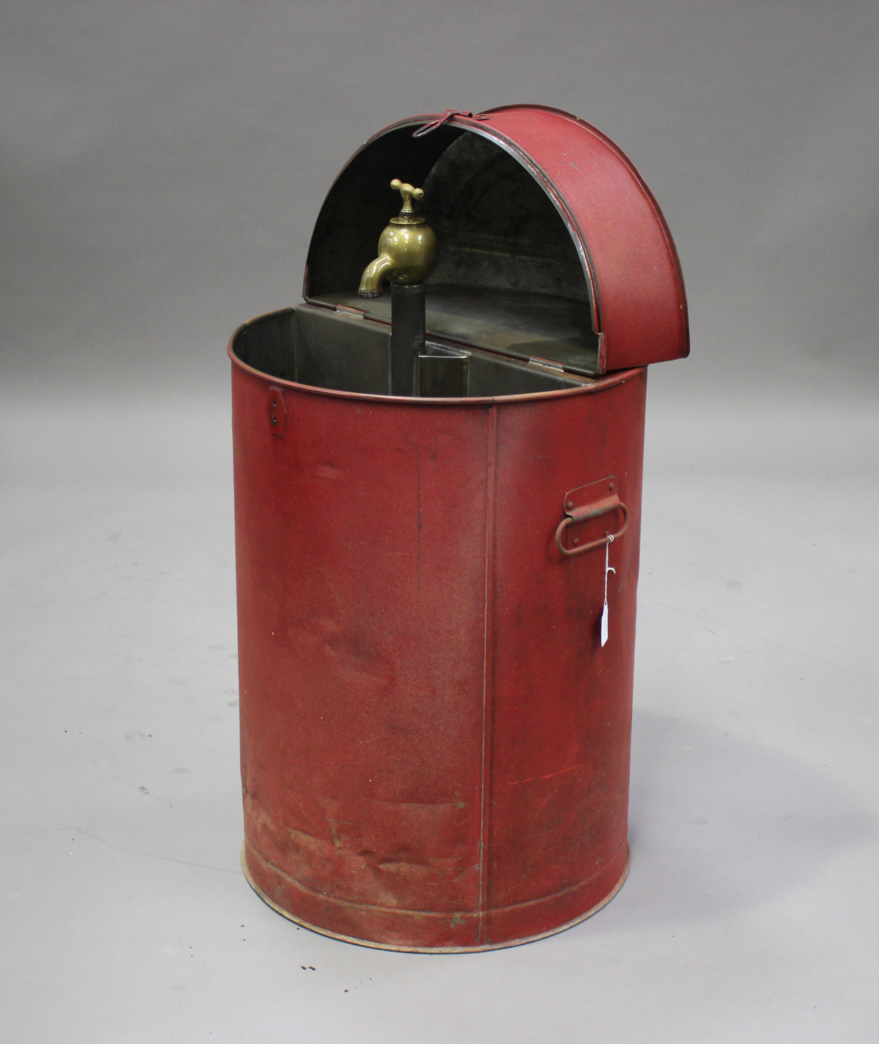 A '30 Gallons' red painted tin oil cabinet, the hinged lid enclosing a brass dispensing tap,