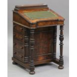 A late 20th century Victorian style walnut Davenport, the hinged writing surface above four drawers,