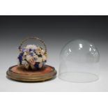A Victorian sailor's valentine shell flower arrangement, set within a basket and contained in a