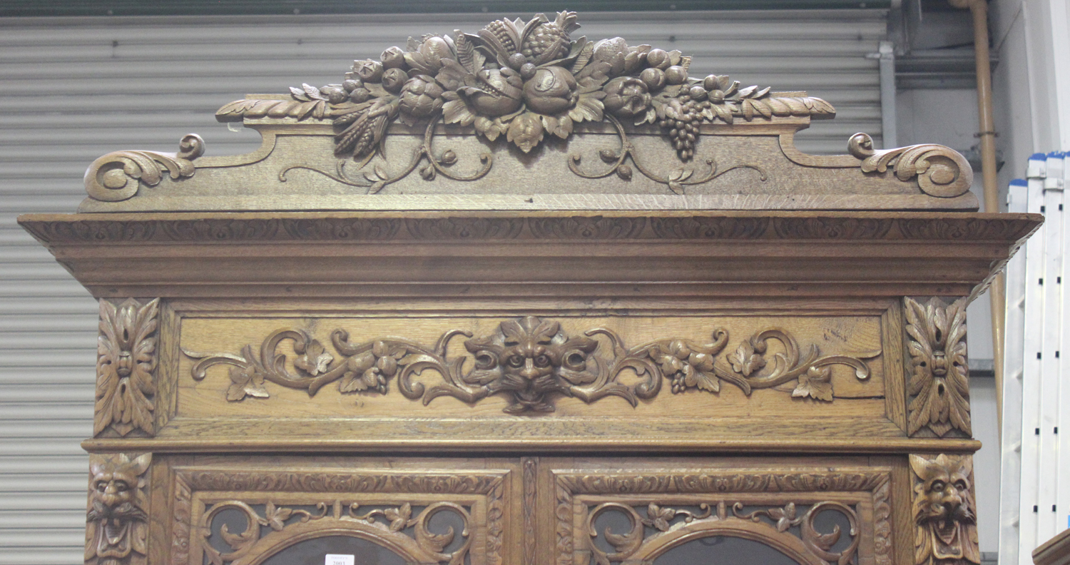 A mid-Victorian oak bookcase cabinet, profusely carved with floral scrolls and masks, the moulded - Image 4 of 4