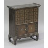 A 20th century Chinese elm medicine cabinet, fitted with twenty inscribed drawers above a
