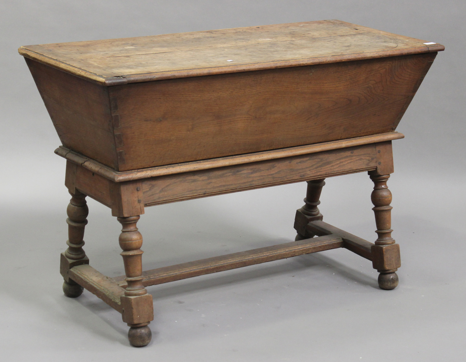 A late 19th/early 20th century Continental fruitwood dough trough on stand, the hinged lid raised on