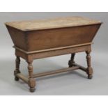A late 19th/early 20th century Continental fruitwood dough trough on stand, the hinged lid raised on