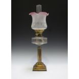 An Edwardian brass and cut glass table oil lamp with frosted glass shade and stepped square base,
