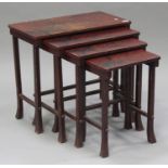 An early 20th century Japanese red lacquered quartetto nest of occasional tables with painted