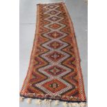 A Turkish flatweave runner, late 20th century, the polychrome field with a single column of hooked