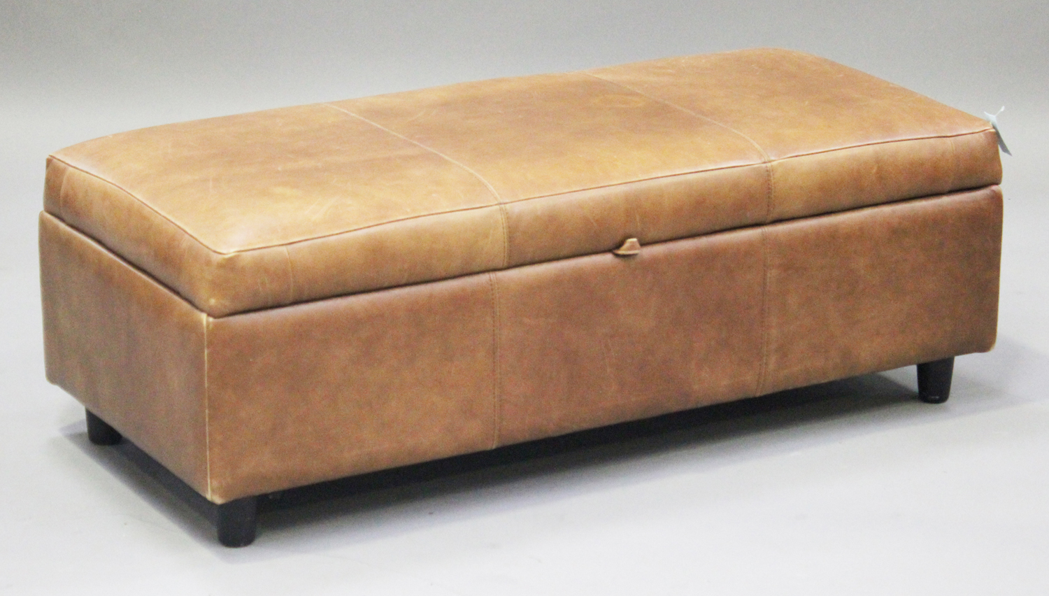 A modern brown leather box seat stool, on turned wooden legs, height 41cm, width 125cm, depth 57cm.