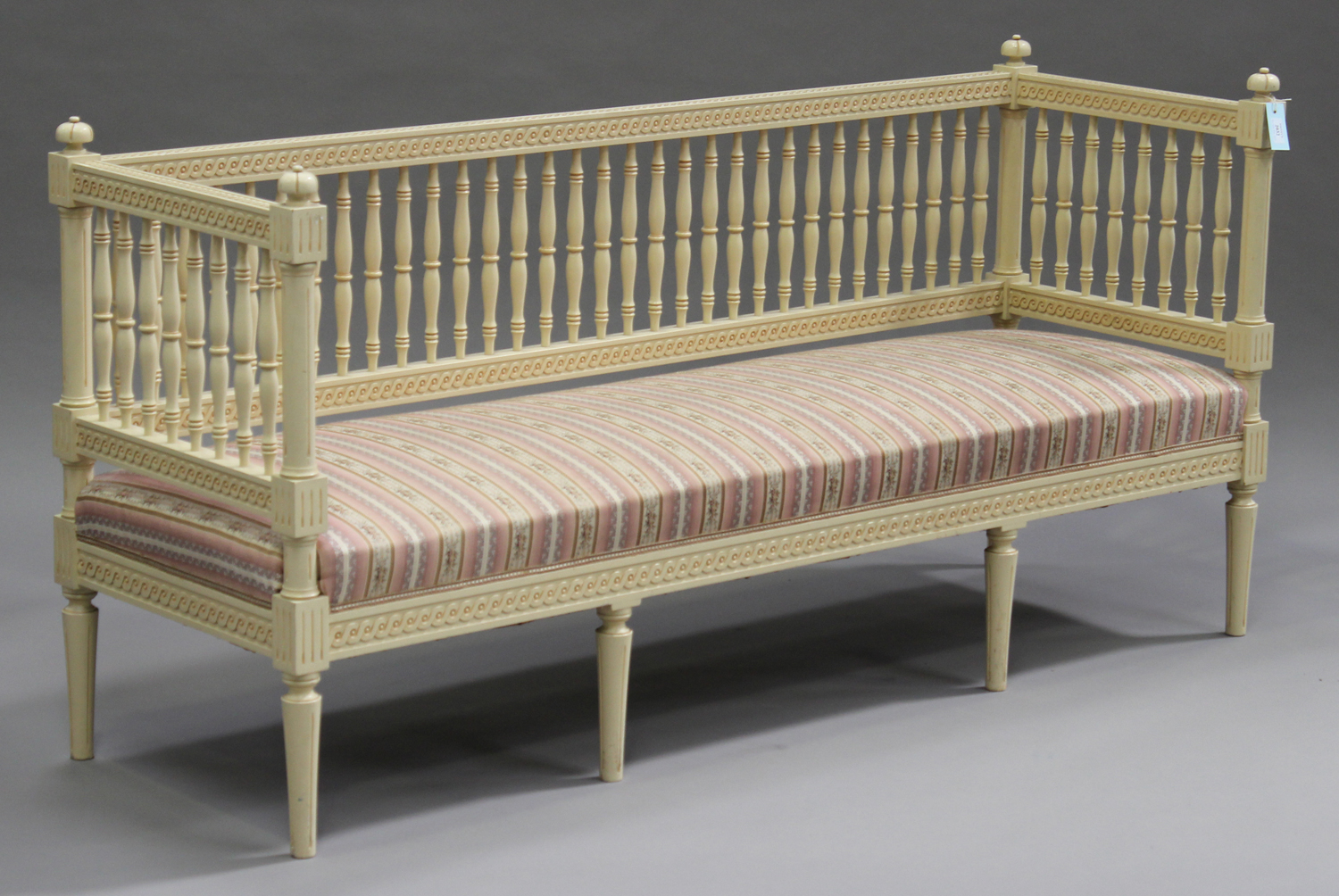 A mid-20th century Swedish cream painted settee, the spindle back and sides above an overstuffed