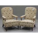 A pair of late 19th/early 20th Century beech and walnut open armchairs, upholstered in a machined