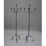 A pair of 20th century wrought iron five light floor standing candelabra, raised on tripod supports,