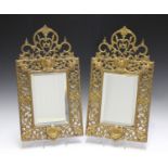 A pair of 19th century cast gilt brass wall mirrors, the frames pierced with foliage and cornered by