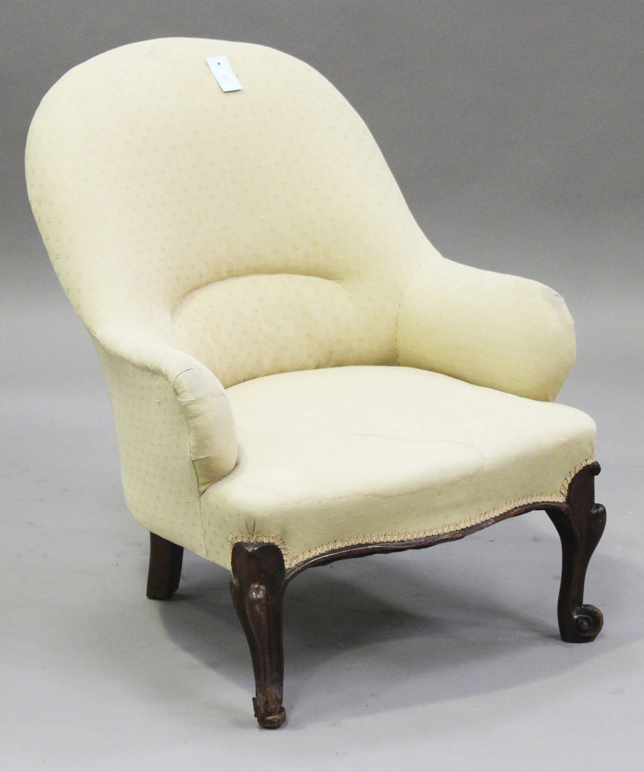A Victorian mahogany tub back salon armchair, upholstered in cream fabric, on cabriole legs,
