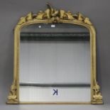 A mid-Victorian giltwood overmantel mirror of arched form with a carved leaf surmount and foliate