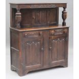 A 20th century Jacobean Revival oak court cupboard with carved decoration, fitted with a central
